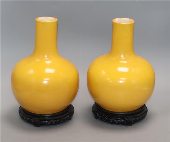 A pair of yellow ground bottle vases, on hardwood stands Height excluding stands 25cm